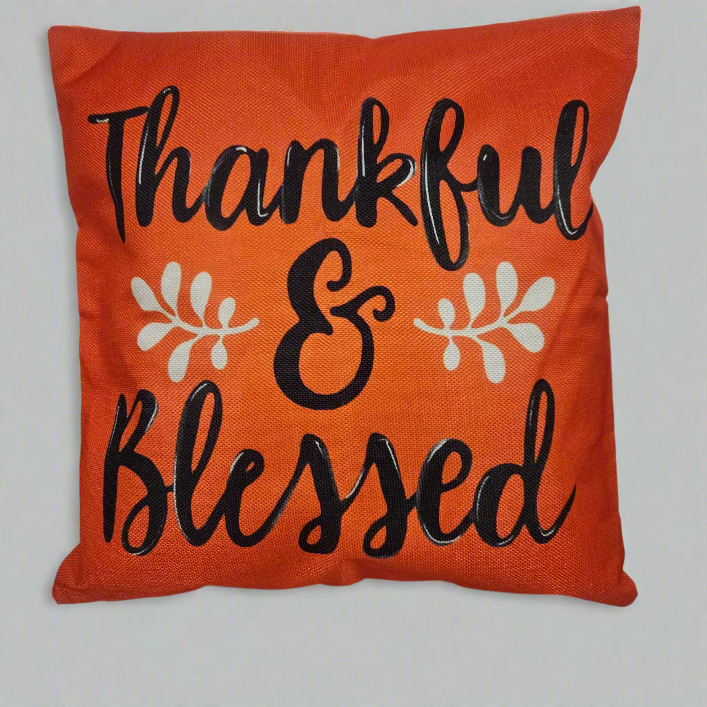 Orange pillow with 'Thankful & Blessed' text on a white background